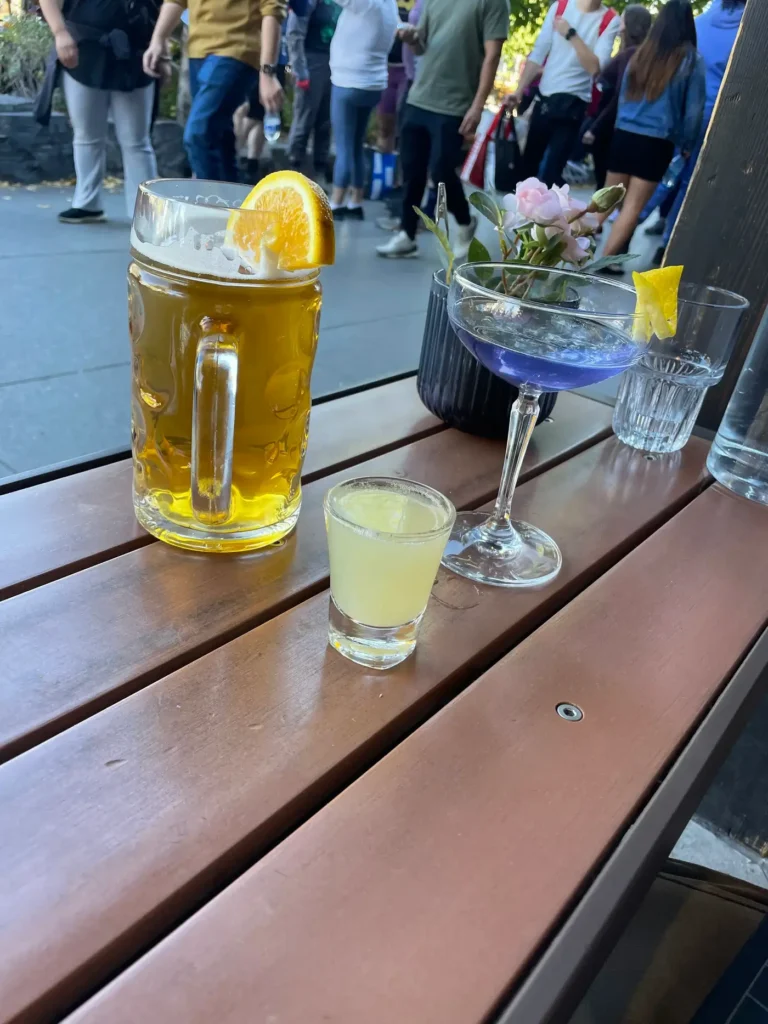 Un cocktail bleu marine avec un shot rempli d'un liquide jaune posé sur une table