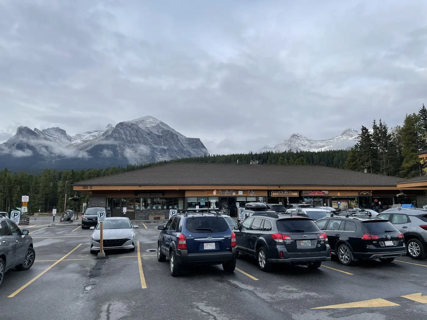 Parking du centre commercial de Lac Louise avec ses boutiques pittoresques et ses montagnes en arrière plan