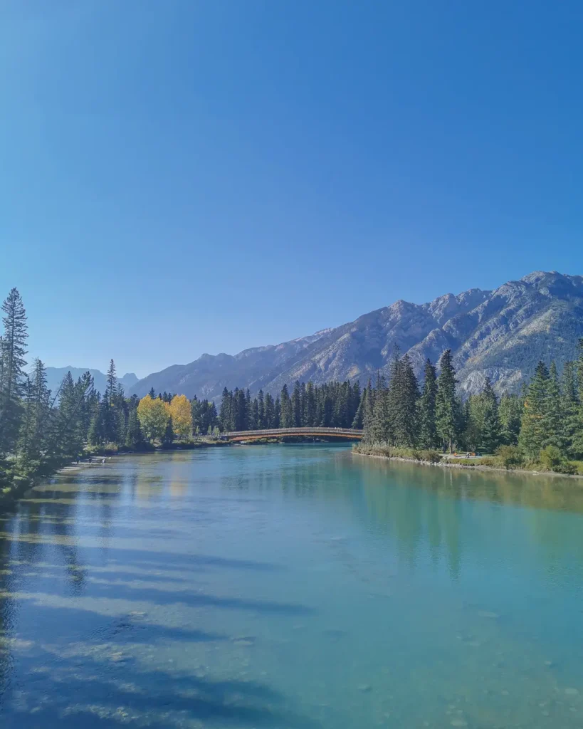 Lac turquoise avec en fond des montagnes sous un ciel bleu