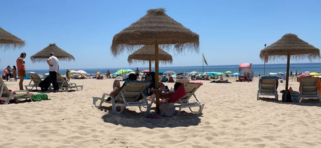 Transats avec parasol en feuille de bananier posés sur la Praia de Mata