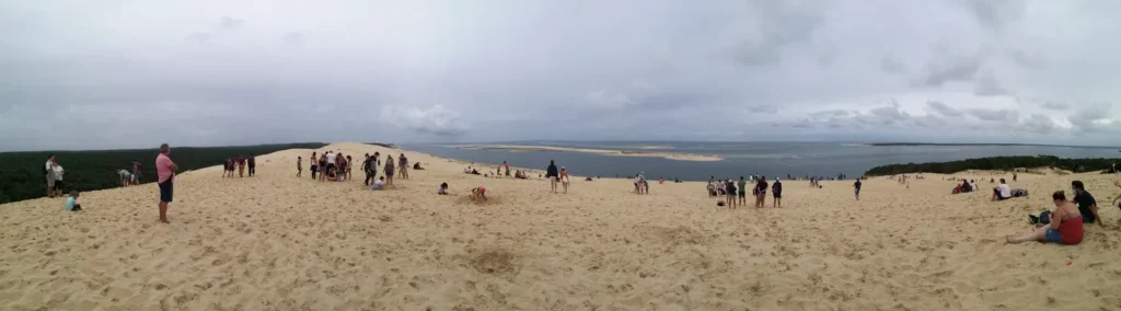 Vue panoramique à 360 degrés de personnes sur la plage, depuis le sommet d'une dune de sable