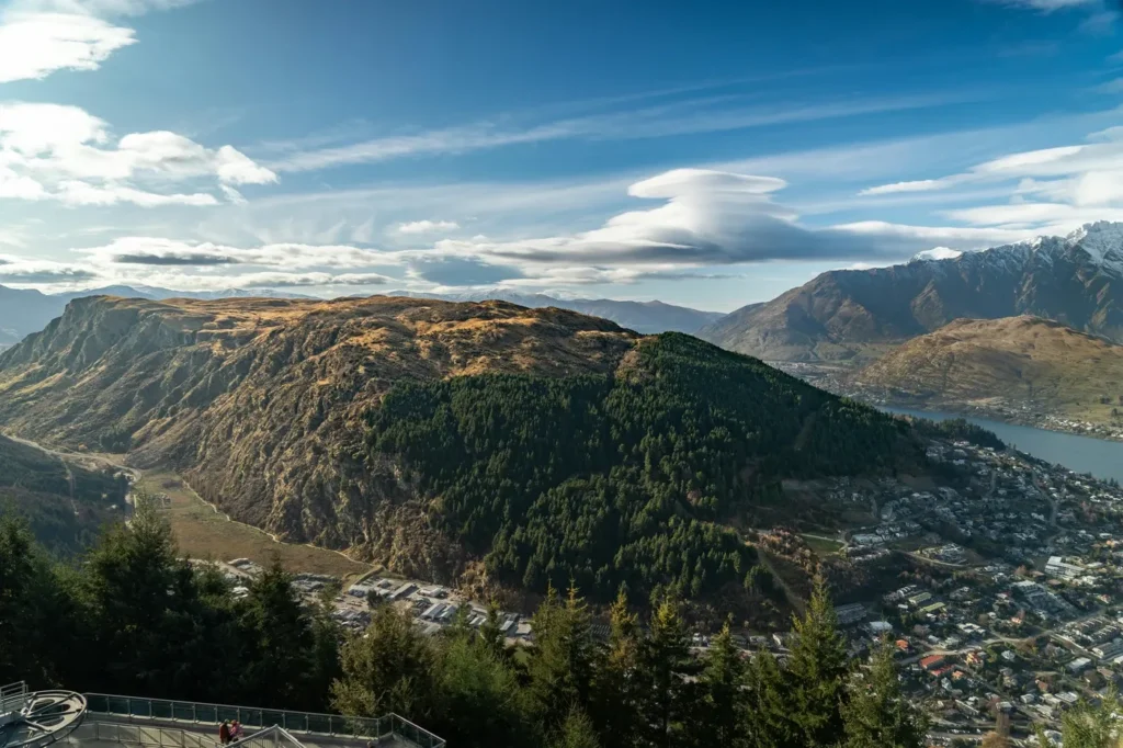 Vue panoramique de Queenstown, Nouvelle-Zélande, avec ses montagnes majestueuses et son lac scintillant.