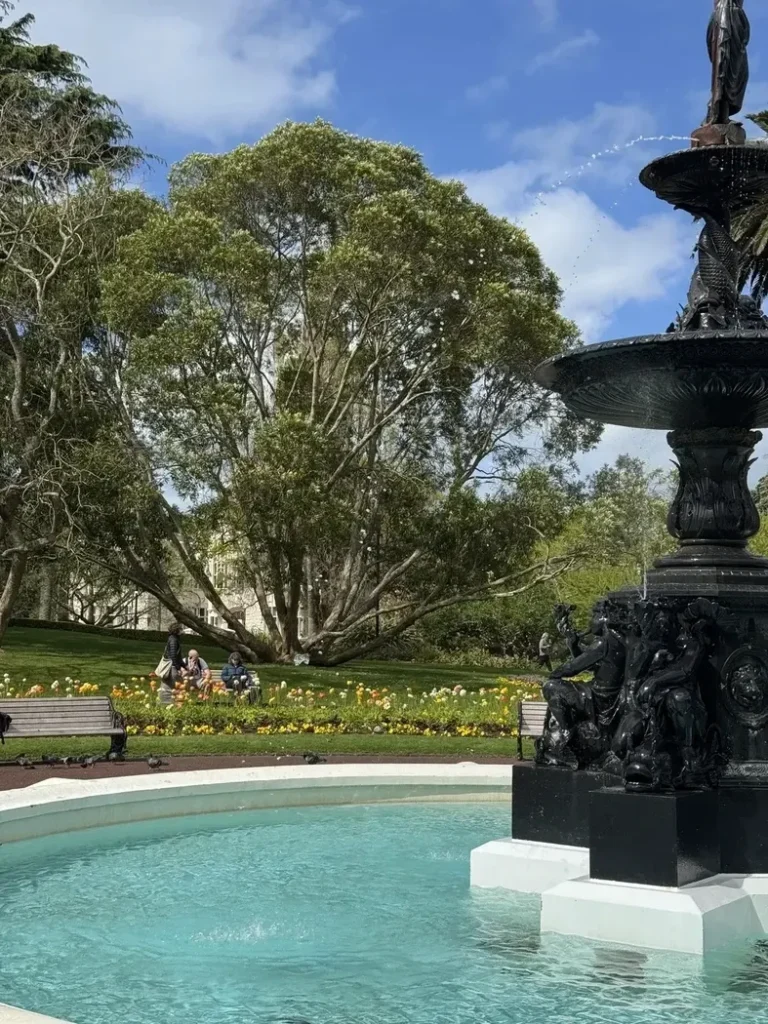 Fontaine en premier plan avec la végétation du parc en arrière plan