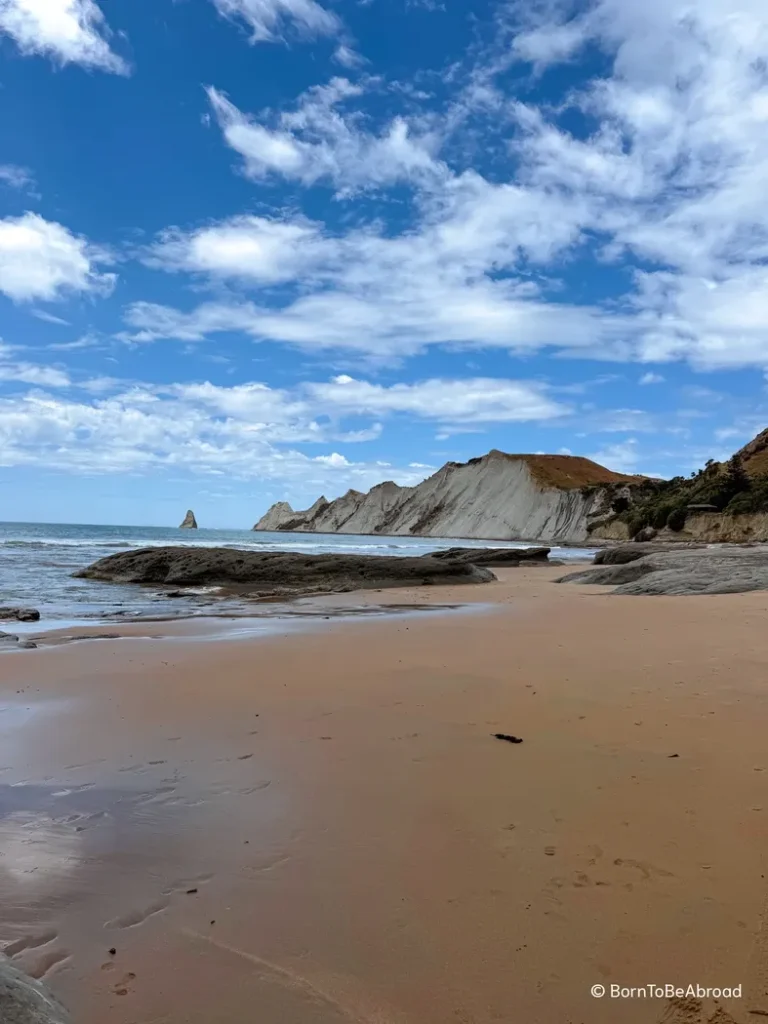 Plage de sable fin sous un temps ensoleillé avec en arrière plan des falaises