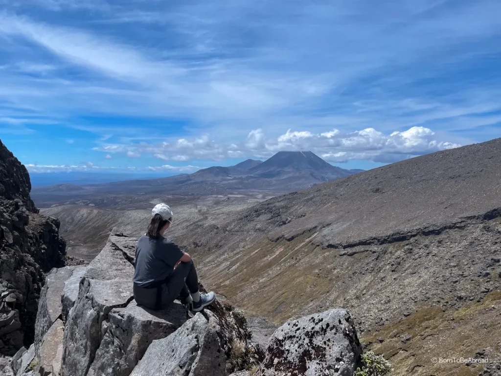 Gwen assise face à la vallée du parc national de Tongariro