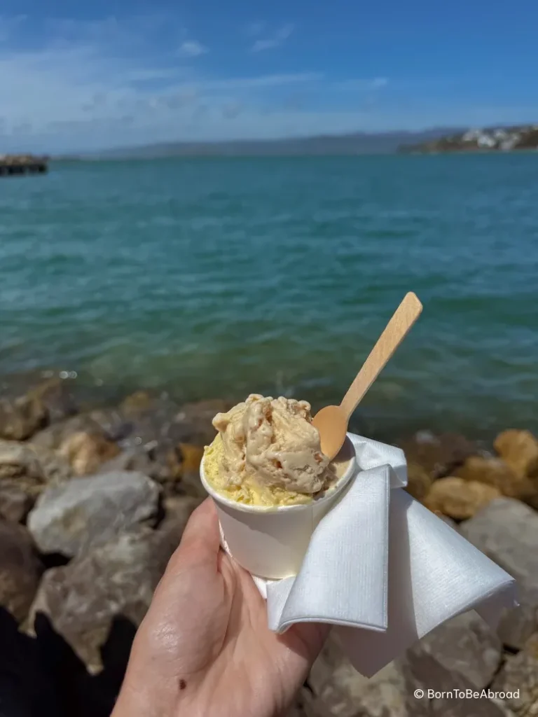 Main tenant une glace à la vanille en face de l'océan