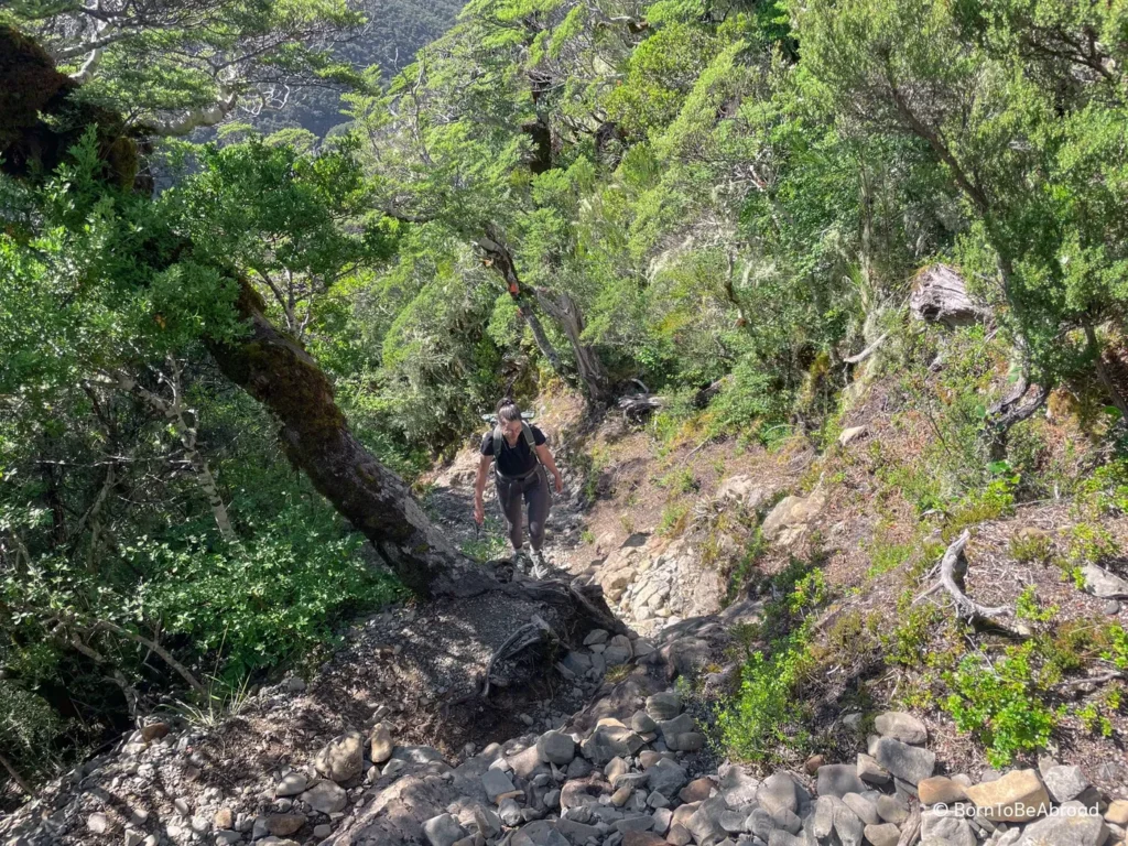 Gwen randonnant sur un sentier très escarpé composé de gros rochers