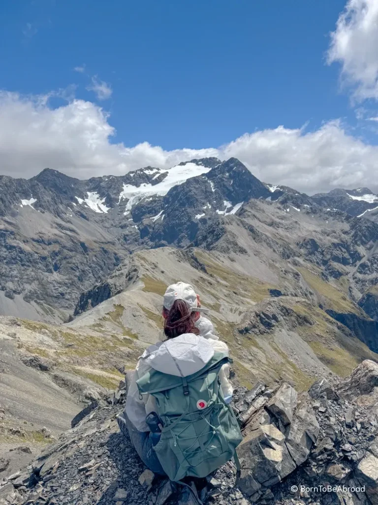 Gwen se tenant assise en face de montagnes enneigées