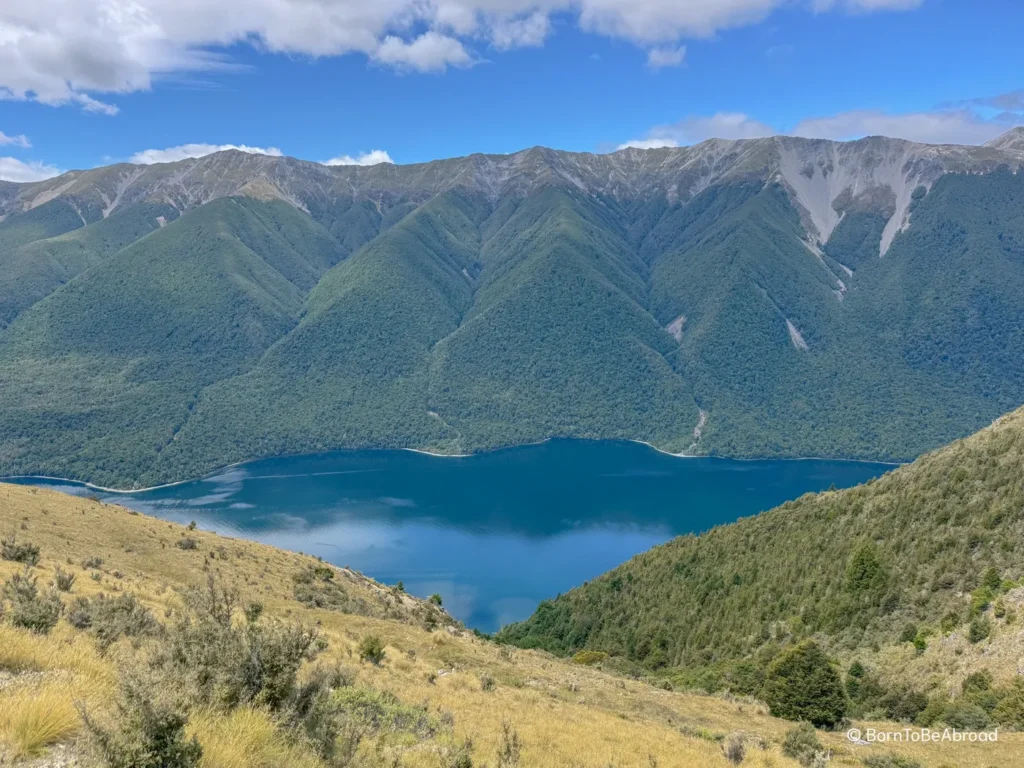 Lac d'une couleur bleu foncé au milieu des collines verdoyantes