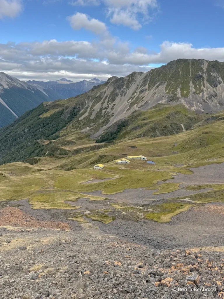 Vue en hauteur sur trois habitations nichées au coeur des montagnes néo-zélandaises