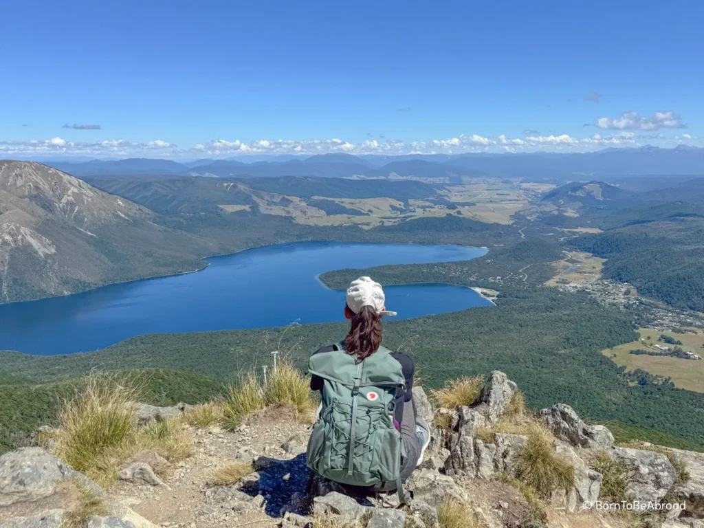 personne regardant la vue panoramique offerte sur le lac Rotoiti et sa vallée