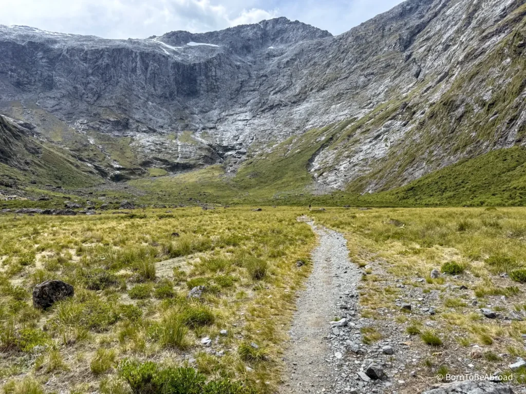Sentier traversant une vallée entourée de montagnes
