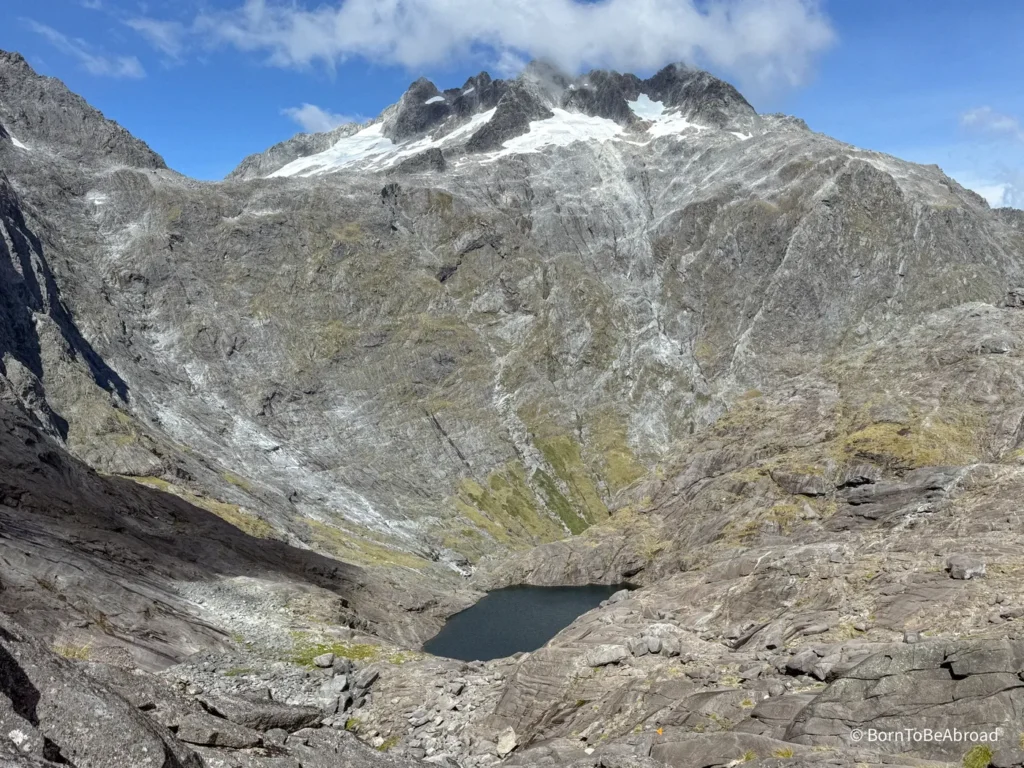 Petit lac bleu niché au pied d'une montage enneigée sous un temps ensoleillé