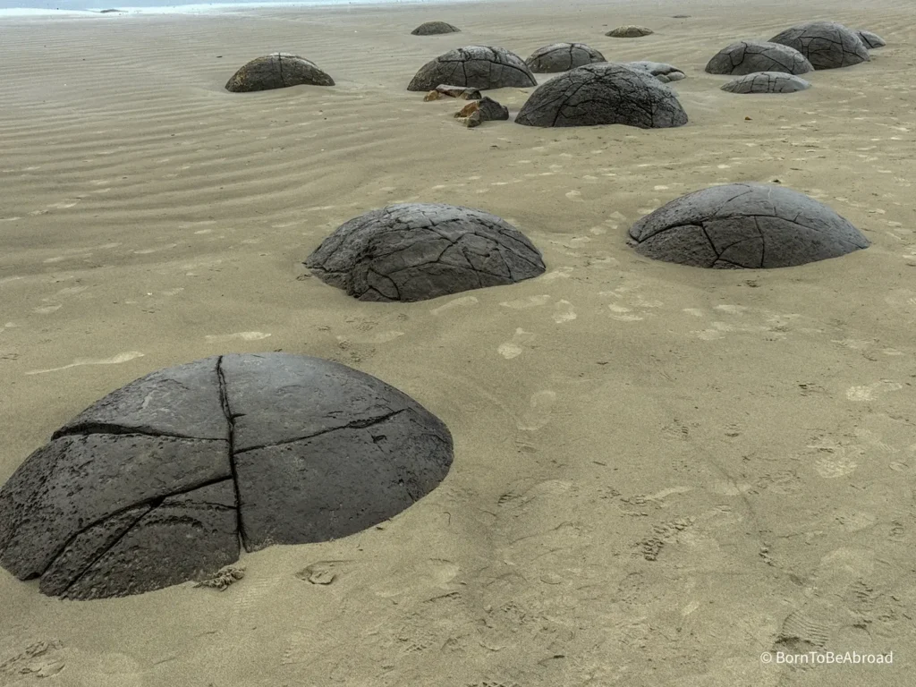 Des rochers de forme sphérique sortant de la plage