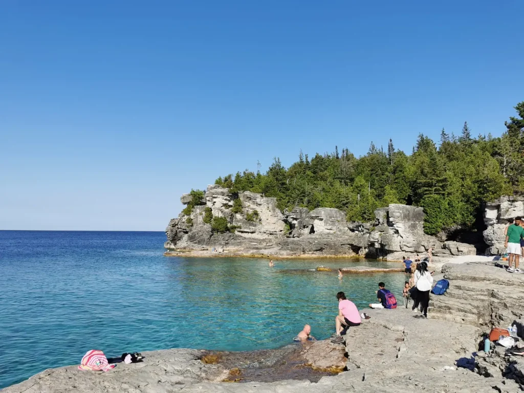 Plage de gros rochers devant le lac aux eaux turquoises