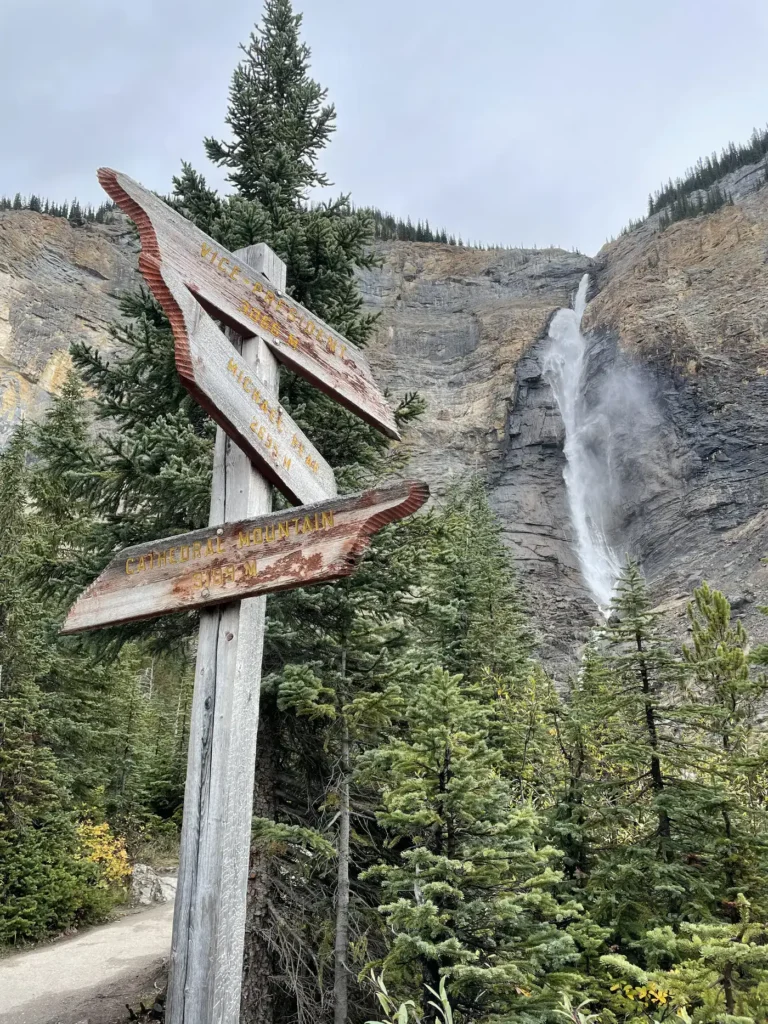 Chutes Takakkaw en arrière plan. Panneau montrant des destinations en arrière plan