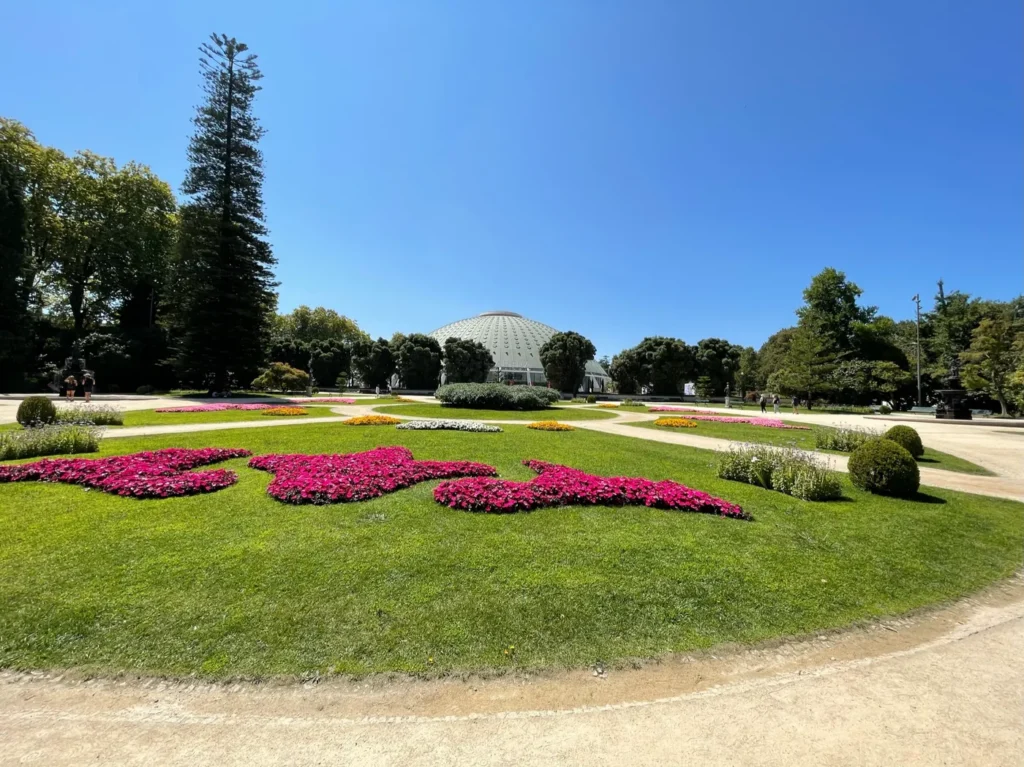 Jardin très bien entretenu avec au fond un bâtiment en forme de dôme