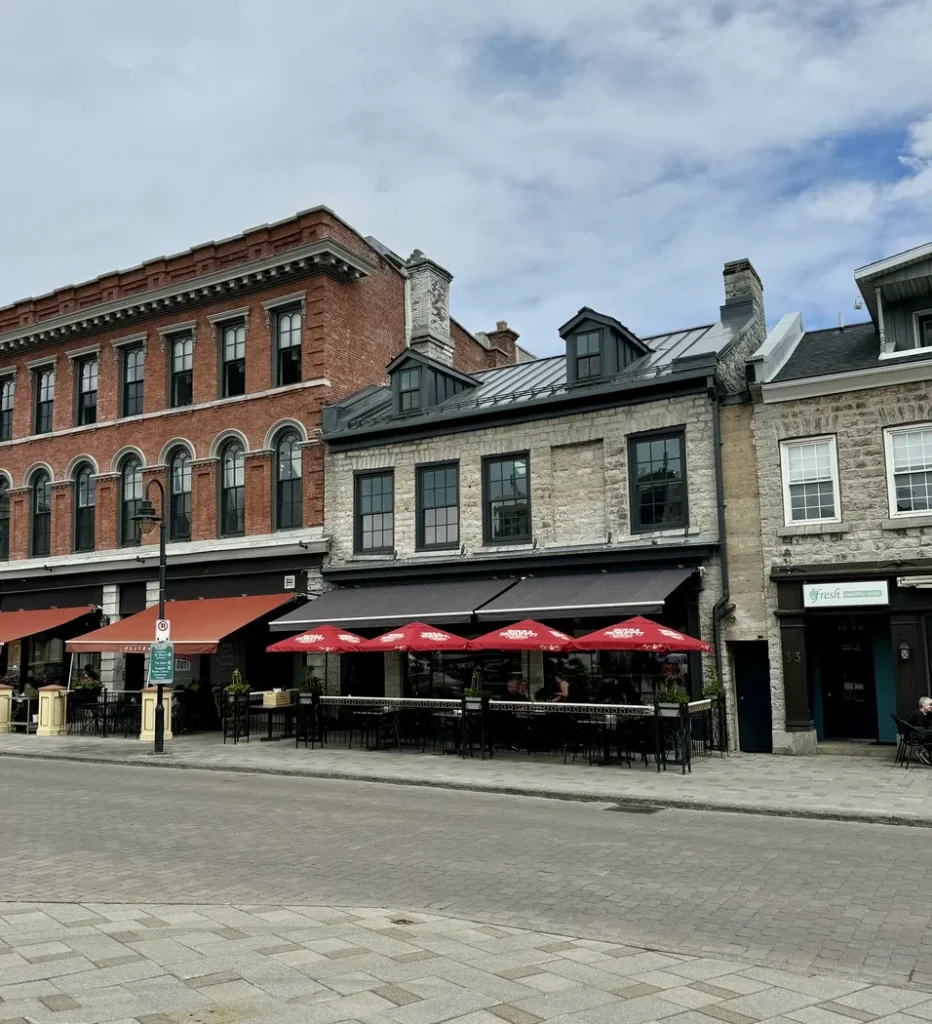 Une rue charmante avec quelques bâtiments et des tables en terrasse, idéale pour se détendre et observer la vie urbaine.